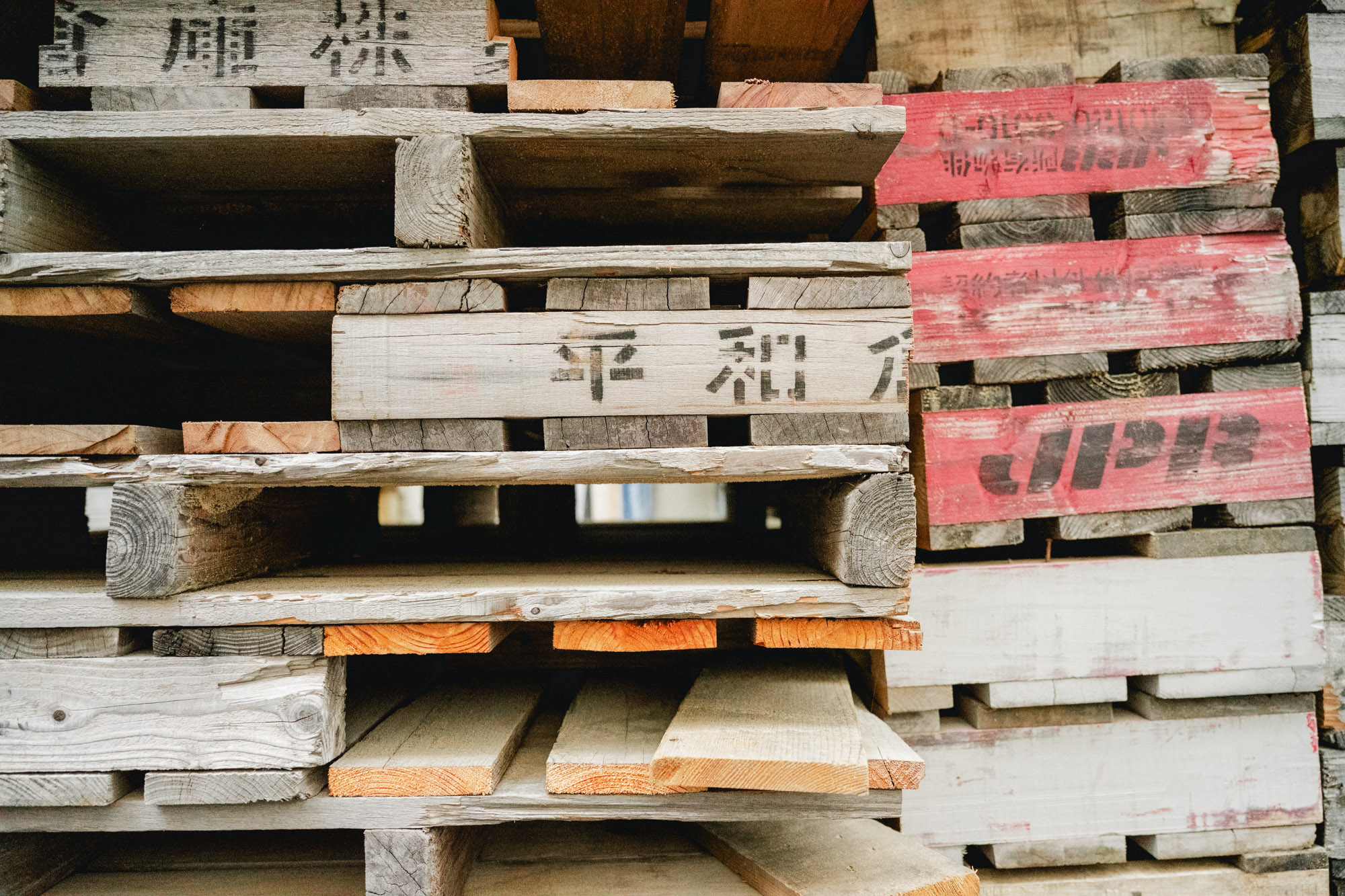 綺麗に積み重ねられた薪用の木製パネル。<br>▶︎藤乃湯とまちについて
